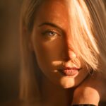 Captivating portrait of a blonde woman bathed in warm golden hour light.